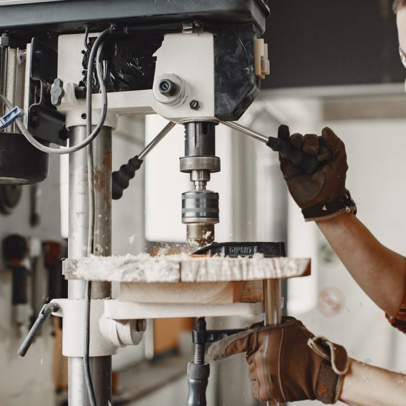 Wood cutting with circular saw. Closeup of mature man sawing lumber.
